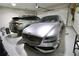Well-lit garage showcasing epoxy flooring, two parked cars, and ample space for vehicle storage at 605 Oak Ln, Canton, GA 30114