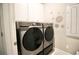 Well-equipped laundry room featuring a modern Samsung washer and dryer, and white cabinets for ample storage at 605 Oak Ln, Canton, GA 30114