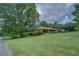 Well-maintained front yard and exterior of the house, featuring a lush lawn and mature trees at 1830 Francis Sw Rd, Conyers, GA 30094