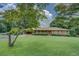 Beautiful ranch-style home showcasing a well-manicured front lawn, mature trees, and red shutters at 1830 Francis Sw Rd, Conyers, GA 30094
