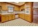 The kitchen features wooden cabinets, white appliances and a black and white tiled floor at 1830 Francis Sw Rd, Conyers, GA 30094
