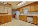 Eat-in kitchen features tile floors, wooden cabinets, and view to other rooms at 1830 Francis Sw Rd, Conyers, GA 30094
