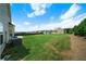 Back exterior featuring a spacious lawn, tree line and several houses in distance at 303 Horizon Trce, Loganville, GA 30052