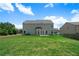 Back exterior featuring a spacious lawn, two story home and tree line at 303 Horizon Trce, Loganville, GA 30052