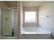 Well-lit bathroom featuring a bathtub and separate shower at 303 Horizon Trce, Loganville, GA 30052
