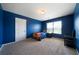 Cozy bedroom with blue walls, carpet flooring, a window with natural light, and a bed at 303 Horizon Trce, Loganville, GA 30052
