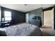 Spacious bedroom featuring a bed, dark accent wall, and adjacent doorway at 303 Horizon Trce, Loganville, GA 30052