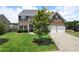 Charming two-story brick home featuring a well-manicured lawn and a two-car garage at 303 Horizon Trce, Loganville, GA 30052