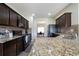 Spacious kitchen featuring dark wood cabinets, granite countertops, and stainless steel appliances at 303 Horizon Trce, Loganville, GA 30052
