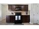 The kitchen has granite countertops, a black stove and microwave, and dark wood cabinets at 303 Horizon Trce, Loganville, GA 30052