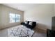 Bright living room featuring a modern sofa, textured rug, and a window at 303 Horizon Trce, Loganville, GA 30052