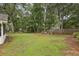Expansive backyard with mature trees, a grassy lawn, fire pit, patio and playground for outdoor enjoyment at 4624 Stonehenge Dr, Atlanta, GA 30360