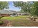 Large backyard with mature trees, patio with outdoor seating, screened porch, and a play area at 4624 Stonehenge Dr, Atlanta, GA 30360