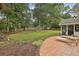 Large backyard with a patio, lounge chairs, mature trees, and a well-maintained lawn at 4624 Stonehenge Dr, Atlanta, GA 30360