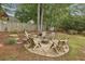 Landscaped backyard with a circular stone fire pit area surrounded by wooden Adirondack chairs at 4624 Stonehenge Dr, Atlanta, GA 30360