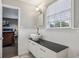 Bathroom featuring a modern vessel sink, black countertop, white cabinetry, and wainscoting at 4624 Stonehenge Dr, Atlanta, GA 30360