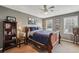 Bedroom with neutral colors and decor, including a wood frame bed, pictures, ceiling fan and two windows at 4624 Stonehenge Dr, Atlanta, GA 30360