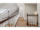 Bright hallway with white railing, brown bannister, skylight and views of a room with a fireplace at 4624 Stonehenge Dr, Atlanta, GA 30360
