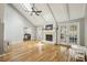 Bright living room featuring hardwood floors, a skylight, a fireplace, and french doors leading to the yard at 4624 Stonehenge Dr, Atlanta, GA 30360