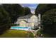 Backyard view of a two-story home with a swimming pool, fenced-in yard and mature trees at 5286 Wild Indigo Nw Way, Acworth, GA 30102