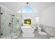 Luxurious bathroom with a modern glass shower, soaking tub, and large windows offering beautiful views at 5286 Wild Indigo Nw Way, Acworth, GA 30102