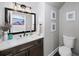 Stylish half bathroom featuring modern fixtures, a decorative mirror, and contemporary decor at 5286 Wild Indigo Nw Way, Acworth, GA 30102