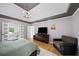 Bright bedroom featuring tray ceilings, hardwood floors, ensuite bath and a large dresser with a TV at 5286 Wild Indigo Nw Way, Acworth, GA 30102