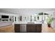 Bright kitchen boasts a large island with seating and stainless steel appliances and overlooks the living room and pool at 5286 Wild Indigo Nw Way, Acworth, GA 30102