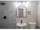 Stylish bathroom with tile shower, arched mirror, modern vanity, and fixtures at 6050 Randy Ln, Ellenwood, GA 30294