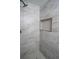 Updated shower with gray tile and a built in shelf at 6050 Randy Ln, Ellenwood, GA 30294