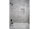 Shower and bath with modern gray tile surround, niche, and black showerhead at 6050 Randy Ln, Ellenwood, GA 30294