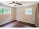 Bedroom with ceiling fan, wood-look floors, and two windows providing natural light at 6050 Randy Ln, Ellenwood, GA 30294