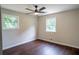 Bright bedroom with hardwood floors, a ceiling fan, and two windows at 6050 Randy Ln, Ellenwood, GA 30294