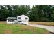 Charming two-story home featuring a bright blue front door, fresh landscaping, and a newly paved driveway at 6050 Randy Ln, Ellenwood, GA 30294