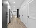 Long hallway with white walls, light wood floors, white doors, and a glimpse of the kitchen at 108 Park Pl # 110, Decatur, GA 30030