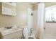 Standard bathroom with toilet, sink, shower, and white tile at 1454 Beecher Sw St, Atlanta, GA 30310