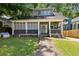 Charming two-story home featuring a screened-in front porch and mature trees at 1454 Beecher Sw St, Atlanta, GA 30310