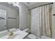 Bathroom featuring a vanity with a mirror, toilet, and tub with patterned curtain at 2324 Blackberry Ct, Snellville, GA 30078