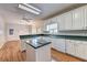 Bright eat-in kitchen with white cabinets, contrasting counter tops, and natural wood flooring at 2324 Blackberry Ct, Snellville, GA 30078