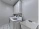 This well-lit laundry room features white cabinets, appliances, and a utility sink at 2324 Blackberry Ct, Snellville, GA 30078