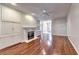 Well-lit living room with a fireplace, hardwood flooring, and integrated storage at 2324 Blackberry Ct, Snellville, GA 30078