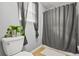 Bathroom featuring a shower with gray curtain, toilet, and small plant at 30 Creek Bottom Dr, Covington, GA 30014
