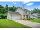 Charming two-story home featuring an attached garage, well-maintained lawn and manicured landscaping at 30 Creek Bottom Dr, Covington, GA 30014