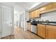 Bright kitchen with wood cabinets, stainless appliances, and adjacent laundry closet at 3301 Henderson Mill Rd # Aa3, Atlanta, GA 30341