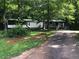 Traditional-style home surrounded by lush trees and greenery with a long driveway leading to the residence at 4744 Chickasaw Se Way, Acworth, GA 30102