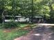 A charming home features a long driveway, large trees, and a cozy front porch at 4744 Chickasaw Se Way, Acworth, GA 30102