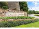 Welcoming stone entrance to Laurel Canyon, enhanced by beautiful landscaping and colorful flowers at 508 Windy Ridge Ct, Canton, GA 30114