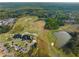 An aerial showcases a golf course, pond, clubhouse with parking, and surrounding homes at 508 Windy Ridge Ct, Canton, GA 30114