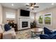 Cozy living room with fireplace, ceiling fan, plush seating, and large windows offering natural light at 508 Windy Ridge Ct, Canton, GA 30114