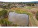 Aerial view of a scenic pond nestled within a lush golf course and residential community at 508 Windy Ridge Ct, Canton, GA 30114